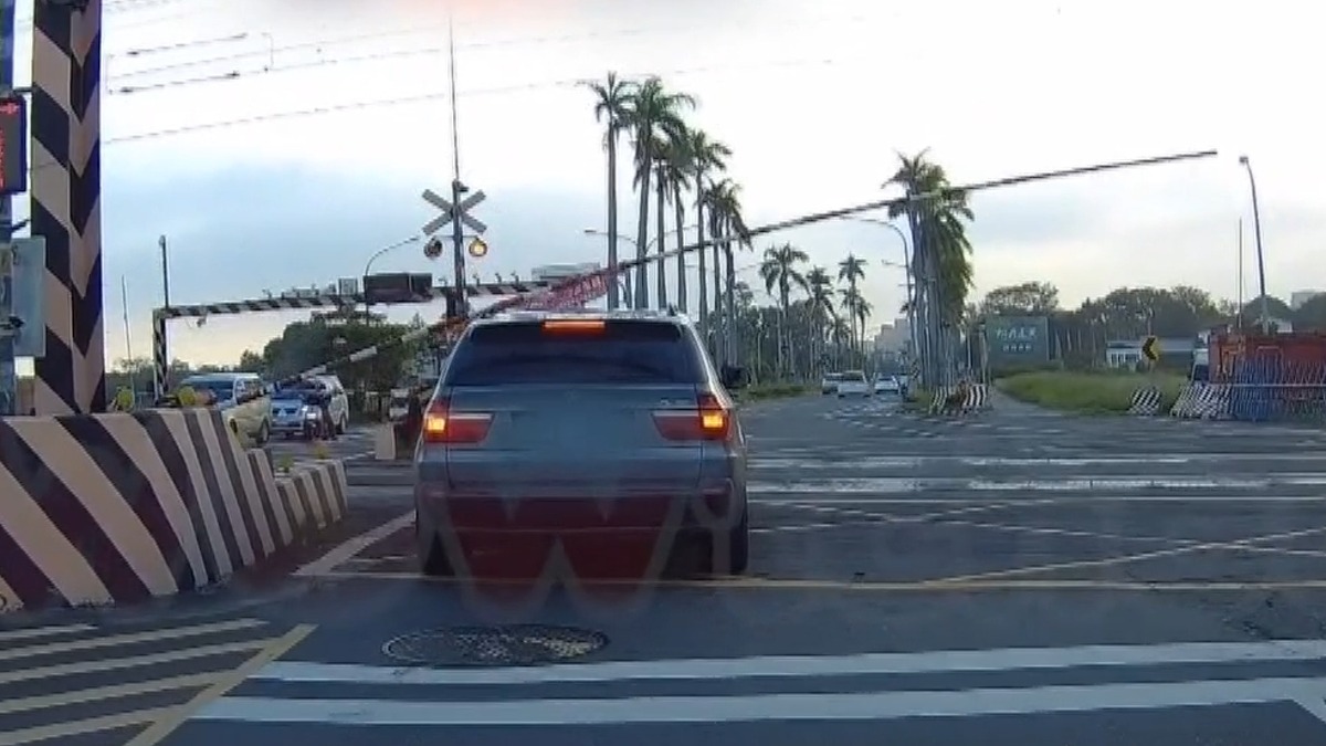 危險！卡平交道黃網區柵欄砸車頂 駕駛急倒退